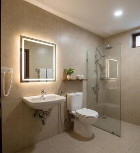 Un baño con inodoro, lavabo y ducha. en Hotel Verano, en Nueva Delhi