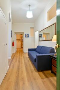 a living room with a blue couch and a mirror at Residenza La Donzella - Appartamento bianco in Campobasso +13 photos