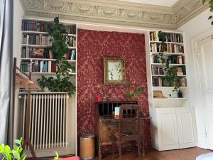 a room with a red wall with book shelves at Sonniges Zimmer Sternschanze in Hamburg