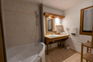 une salle de bain avec une baignoire et un lavabo dans l'établissement Cosy du Birdie Logement 4 pers avec piscine, à Giez