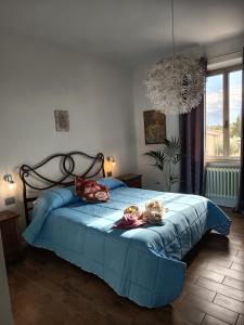 a bedroom with a blue bed with two dolls on it at Bully casa Vacanze in Spello