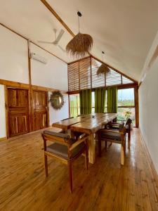 a dining room with a wooden table and chairs at Dar Mar Hostel & Coworking in Paje