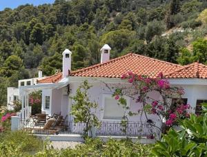 une maison blanche avec un toit rouge dans l'établissement Poros Thea Villa, à Poros