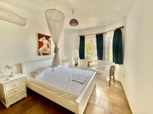 une chambre blanche avec un lit et une commode dans l'établissement Poros Thea Villa, à Poros