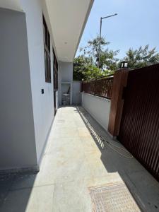 a balcony of a white building with a wooden fence at 2BHK Semifurnished House in Greater Noida