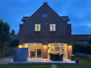 a large brick house with glass doors and windows at Linnebarg Hus 4 in Fehmarn