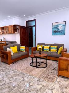 a living room with couches and a table at Maja Apartments Kampala in Kampala