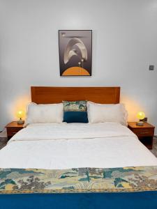 a bedroom with a large bed with two lamps at Maja Apartments Kampala in Kampala