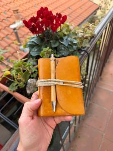 a person holding a brown wallet in front of flowers at B&B Al 27 in Paderno dʼAdda