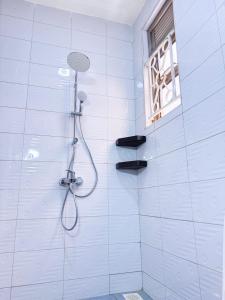a shower with a shower head in a bathroom at Maja Apartments Kampala in Kampala