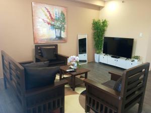 a living room with a couch and a tv at Urban Zen - Family Condo with Parking in Nuvali in Calamba