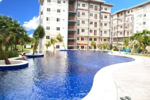 a large swimming pool in front of a building at Urban Zen - Family Condo with Parking in Nuvali in Calamba