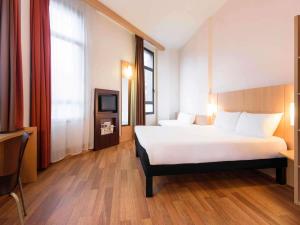 a hotel room with a bed and a tv at Ibis Bilbao Centro in Bilbao