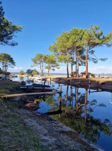 ein Fluss mit einem Dock und Bäumen am Ufer in der Unterkunft Mobilhome 6 personnes Marvilla Parks - Mayotte Vacances in Biscarrosse