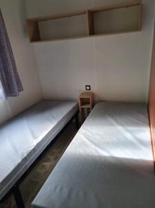 2 Betten in einem kleinen Zimmer mit in der Unterkunft Mobilhome 6 personnes Marvilla Parks - Mayotte Vacances in Biscarrosse + 11 Fotos