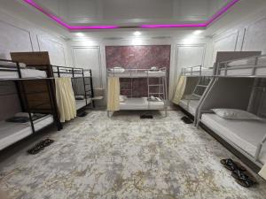 Salor BekatiにあるHovli Hostelの二段ベッドが4つと紫色の照明のある部屋 +8枚の写真