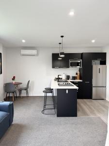 Una cocina y sala de estar con electrodomésticos en blanco y negro. en Private self contained unit, en Pukekohe East