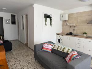 Una sala de estar con un sofá y una cocina. en Casa Ermita El Medano, en El Médano 7 fotos más