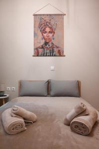 een bed met twee kussens en een schilderij aan de muur bij Stellina's Spot in Larisa