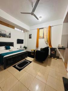 a large bedroom with a bed and a couch at Charming Studio in Mombasa