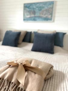 a bed with a bow on it with blue pillows at Chiemsee Häuschen in Prien am Chiemsee