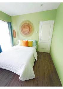 a bedroom with a white bed and a window at Urban Zen in Calamba +35 photos