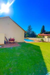 a yard with a bench next to a house at Inocova Fly in Kempton Park