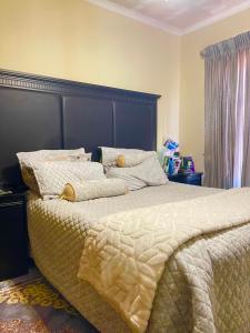 a bedroom with a large bed with a black headboard at Inocova Fly in Kempton Park