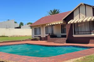 a house with a swimming pool in front of it at Inocova Fly in Kempton Park