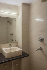 a bathroom with a sink and a mirror at Vinayaka Heritage in Patna