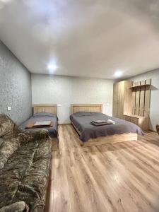 ボルジョミにあるN&G Apartmentのベッド2台とソファのある寝室