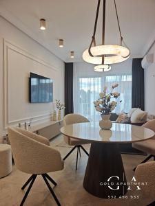 a living room with a dining table and a couch at Gold Apartment E54 Let's Sea Baltic Park Gąski in Gąski