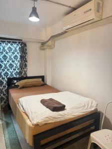 a bedroom with a bed with a towel on it at 42 Guest House in Bangkok