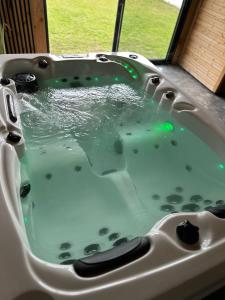 OyréKourline Villalunoterie Futuroscope Piscine spa的水槽内装满水的浴缸