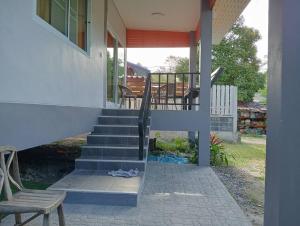a house with a staircase and a chair on a porch at Silva Haus in Ban Nua