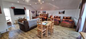 a living room with two beds and a couch and a table at Windsor Cottage on The Big "W" Ranch in Nether Wasdale +51 photos