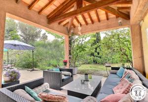 patio esterno con divani e ombrellone di Le Loft de la garrigue a Cadolive