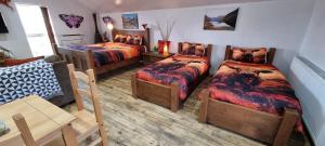 a room with three beds and a table and chairs at Windsor Cottage on The Big "W" Ranch in Nether Wasdale