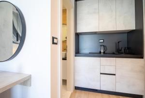 a kitchen with white cabinets and a mirror at Mediteran in Tučepi +108 photos