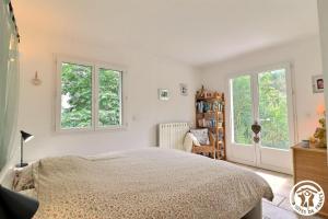 una camera da letto con un letto e due finestre di Le Loft de la garrigue a Cadolive