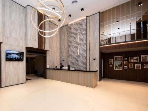 a lobby of a building with a chandelier at Grand Mercure Bangkok Asoke Residence in Bangkok