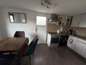 a kitchen with a wooden table and a table and chairs at Small House park free at street in Stuttgart