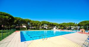 a large swimming pool with people standing around it at Olimpia in Bibione