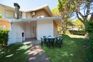 a patio with a table and chairs in a yard at Olimpia in Bibione