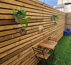 a wooden fence with a bench and a potted plant at Court Studio Apartment in Cardiff