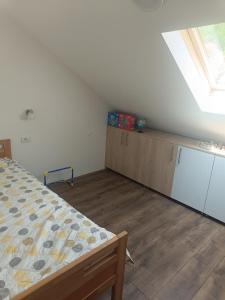 a bedroom with a bed and cabinets and a window at NiLa in Ivanjica
