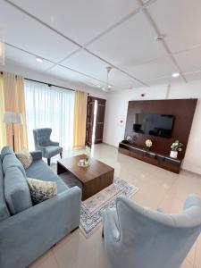 a living room with a couch and a tv at The Altura Apartment in Mount Lavinia