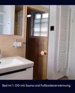 a bathroom with a sink and a toilet and a mirror at Claras Strandhuus in Zingst