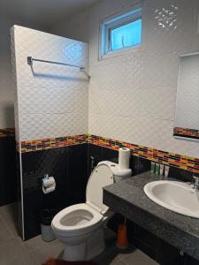 a bathroom with a toilet and a sink at Cozy 1-Bedroom apartment in Ban Lum Fuang +4 photos