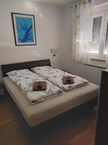 Una cama con dos almohadas encima en un dormitorio. en Apartma Laura, en Ankaran